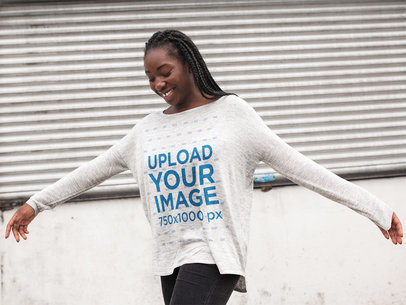 Happy Woman with Locks Wearing a Bella Flowie Long Sleeve Loose Tee Template While Having Fun Outdoors