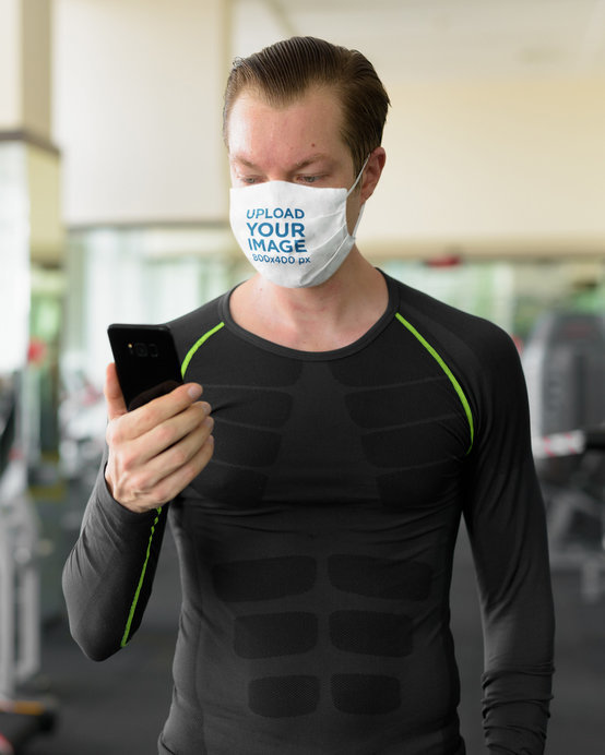 Face Mask Mockup of a Man at a Gym Checking His Phone
