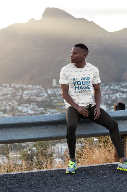 Round-Neck T-Shirt Mockup Featuring a Man Sitting Against a City View