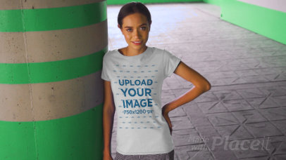 T-Shirt Video of a Happy Young Woman Posing by a Concrete Column