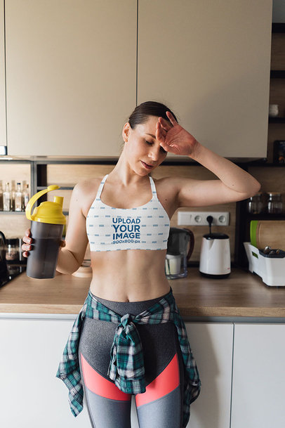 Sports Bra Mockup of a Woman Drinking Water at Home After a Workout