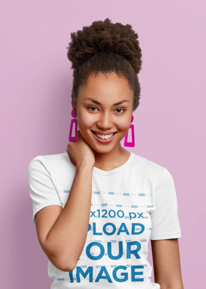 Mockup of a Woman with Pink Earrings Wearing a T-Shirt in a Studio