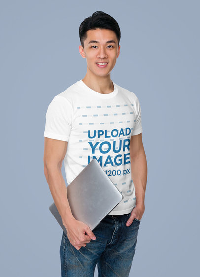T-Shirt Mockup of a Young Man Holding a Laptop in a Studio m7325-r-el2