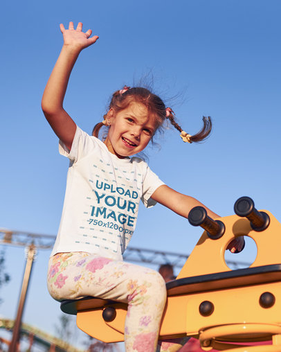 T-Shirt Mockup Featuring a Happy Little Girl at a Playground