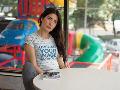 Serious Woman Wearing a Sublimated Tee Mockup While at a Fast Food Resturant