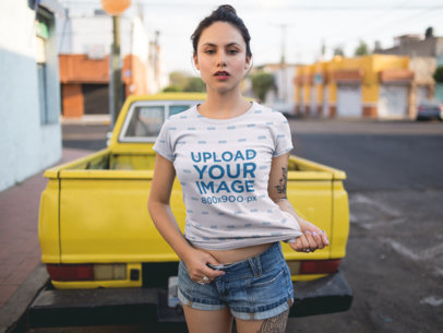 Young Woman Wearing a Round Neck Tee Mockup While Against a Yellow Pick Up Truck in the Street