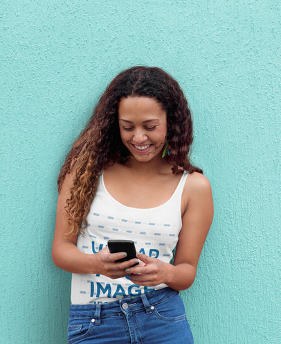 Tank Top Mockup of a Happy Woman Using Her Mobile Phone