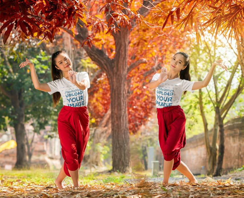 V-Neck Tee Mockup Featuring Two Women Posing Under a Brown-Leaf Tree
