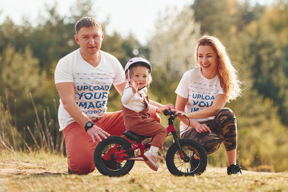 T-Shirt Mockup Featuring a Mom and a Dad Teaching Their Daughter to Ride a Bike