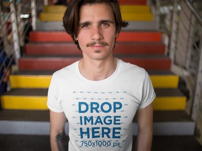 Smiling Dude Wearing a Round Neck Tee Mockup While Near Colorful Stairways