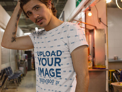 Guy with Moustache Grabbing his Hair While Wearing an All Over T-Shirt Mockup Inside an Urban Market a15370