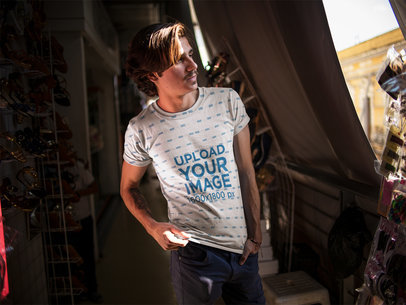 Sublimated Round Neck Tee Mockup Being Worn by a White Dude Walking in a Dark Hall