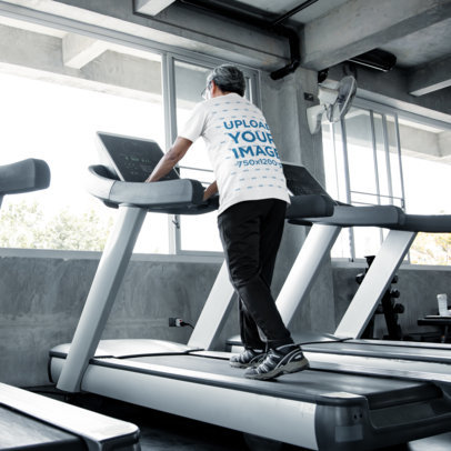 Back-View T-Shirt Mockup of a Senior Man Using a Treadmill