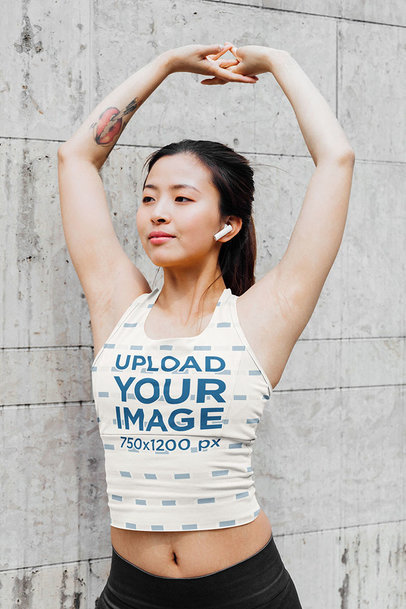 Sublimated Tank Top Mockup Featuring a Tattooed Woman Stretching Her Arms 