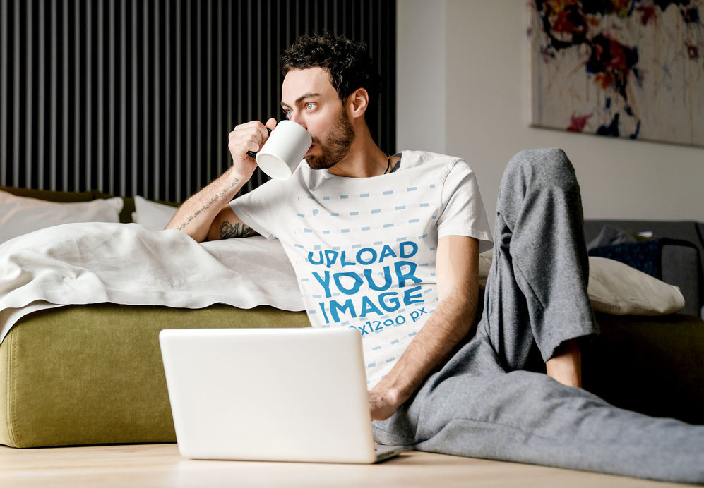 T-Shirt Mockup of a Man Drinking Coffee While Working From Home