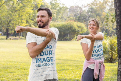 T-Shirt Mockup Featuring a Couple Stretching Their Arms at a Park