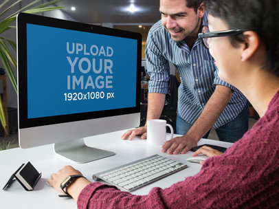 Mockup of a Man and a Woman Working at the Office with an iMac