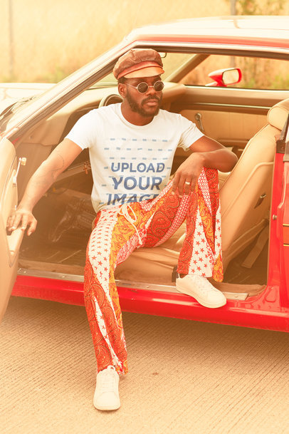 T-Shirt Mockup of a Man Wearing a 70's Outfit on a Muscle Car m10489