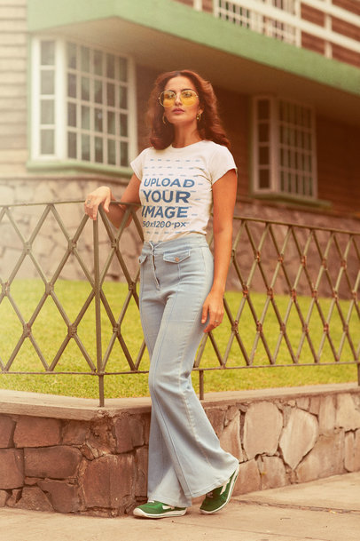 T-Shirt Mockup of a Woman Leaning on a Fence in the 70s m10129
