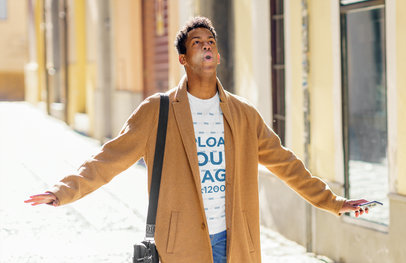 T-Shirt Mockup Featuring a Man Walking Down the Street