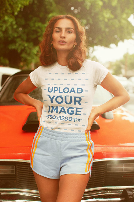 Tee Mockup of a Woman in a 70's Summer Outfit by a Classic Car