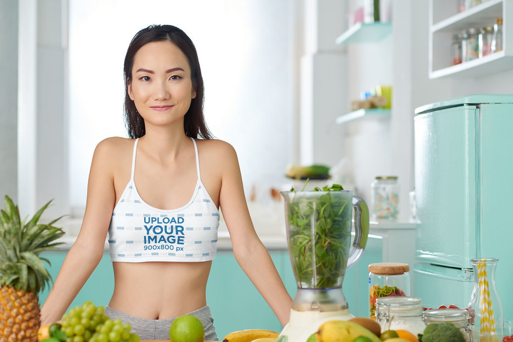 Sports Bra Mockup Featuring a Woman Making a Green Smoothie