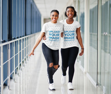 T-Shirt Mockup of Two Happy Women Hugging and Walking Down the Hall