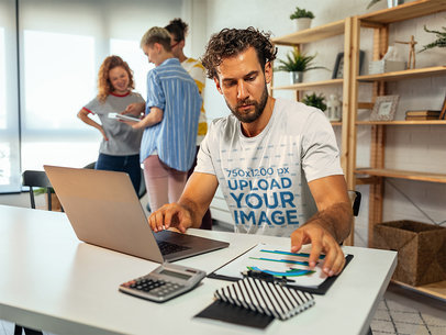T-Shirt Mockup of a Bearded Man Working From His Desk
