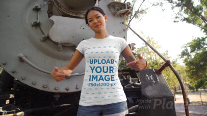 T-Shirt Video Mockup of a Tattooed Woman Posing Next to an Old Locomotive 