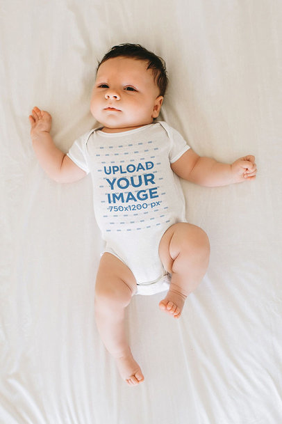 Mockup of a Baby Wearing a Onesie and Laying on a White Sheet m10815 r-el2