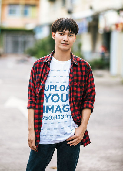 T-Shirt Mockup of a Young Smiling Man Posing on an Empty Street