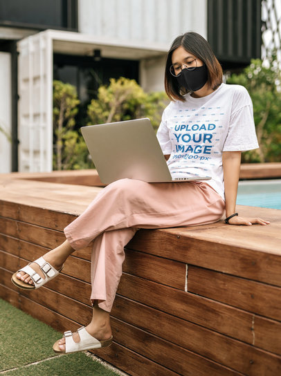 Unisex T-Shirt Mockup Featuring a Young Woman Working by a Pool