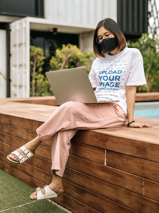 Unisex T-Shirt Mockup Featuring a Young Woman Working by a Pool