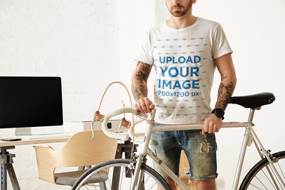 T-Shirt Mockup of a Man with Arm Tattoos Standing by His Bike