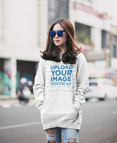 Heather Pullover Hoodie Mockup of a Serious Woman With Sunglasses Posing in the Street