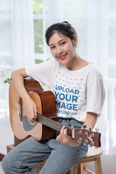 T-Shirt Mockup of a Cheerful Woman Playing the Guitar