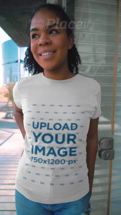 T-Shirt Video of a Smiling Woman Posing by a Building