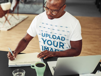 T-Shirt Mockup of a Man with Glasses Taking Notes at Work