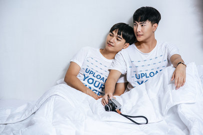 Round-Neck Tee Mockup Featuring Two Happy Men Lying in Bed With an Old Camera