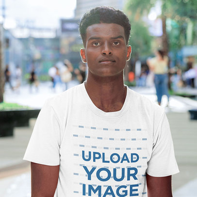 T-Shirt Mockup Featuring a Man Posing in the City With a Serious Look