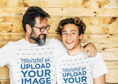 T-Shirt Mockup Featuring a Bearded Man Posing With His Son Against a Wooden Wall