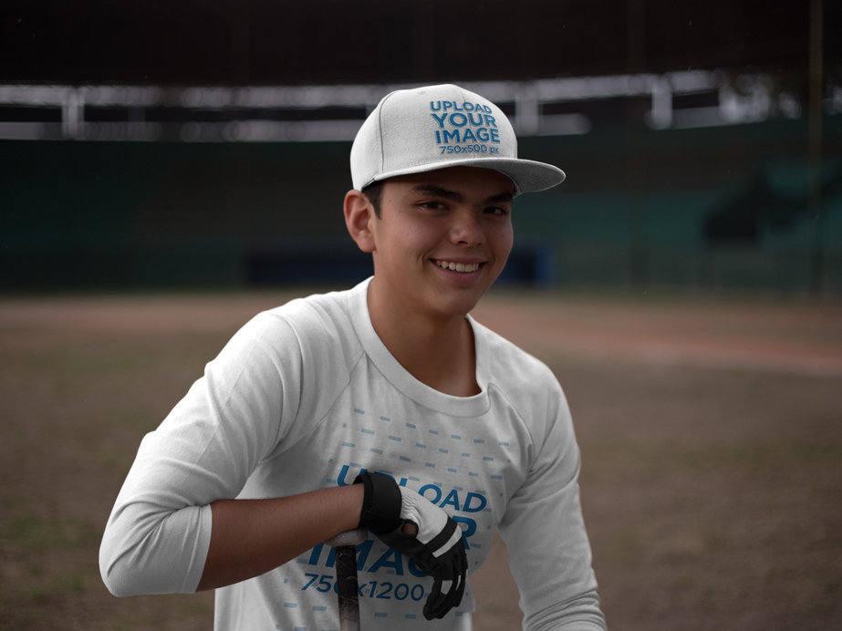 Smiling Hitter Boy Wearing a Baseball Hat Mockup and a Raglan Tshirt at the Field