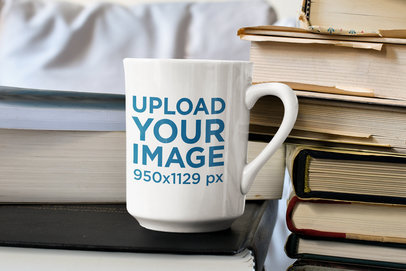 Mockup of a 15 oz Coffee Mug Placed over a Pile of Books