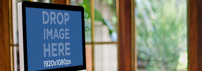 Wide Mockup of an iMac on a Wooden Desk