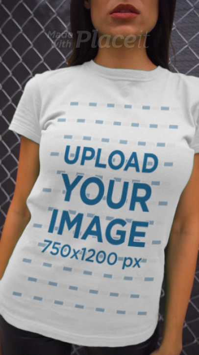 Video Featuring a Young Woman Wearing a T-Shirt and Posing by a Metal Fence 