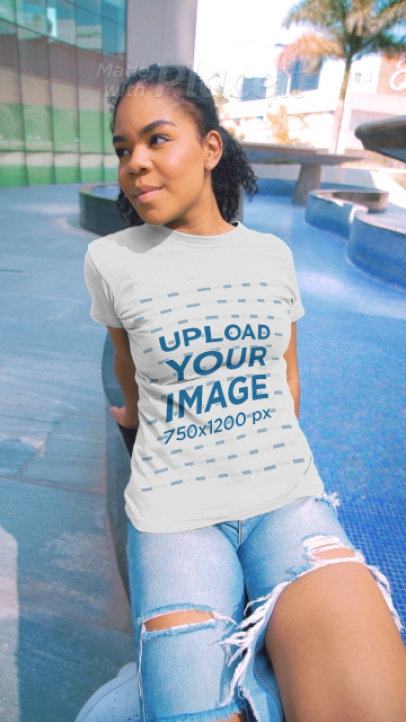 T-Shirt Video Featuring a Happy Woman Posing by a Fountain