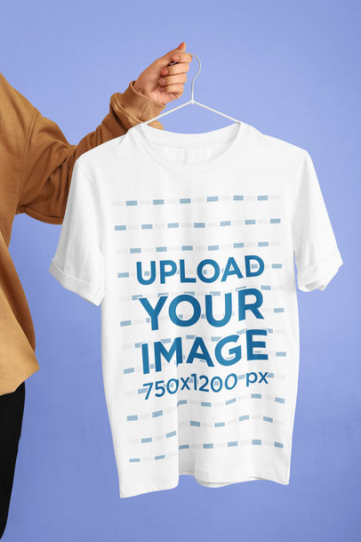 Mockup of a Woman Holding a Hanger With a Round-Neck Tee