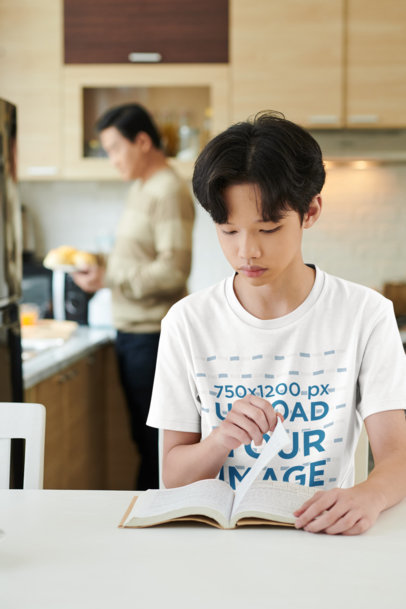 Round-Neck T-Shirt Mockup Featuring a Teenage Boy Reading a Book