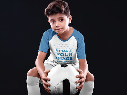 Custom Soccer Jerseys - Kid Holding the Ball While SItting Down