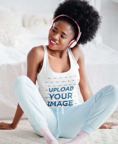 Tank Top Mockup of a Woman with Headphones Sitting in Her Bedroom